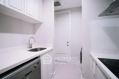 Modern kitchen with sleek white cabinetry and built-in appliances