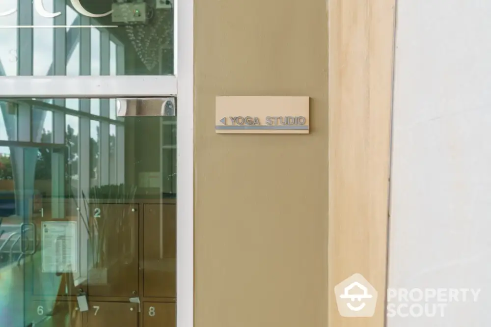 Modern yoga studio entrance with glass door and lockers