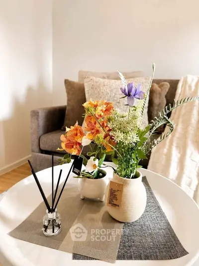 Stylish living room with cozy sofa and elegant floral arrangement on a chic coffee table.