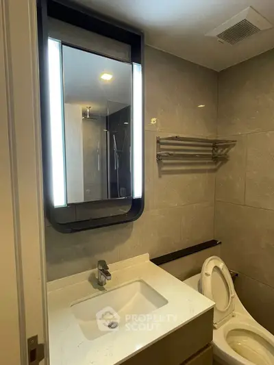 Modern bathroom with illuminated mirror and sleek fixtures