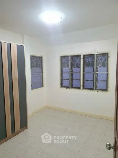 Bright empty room with tiled floor and modern wardrobe, ideal for customization.