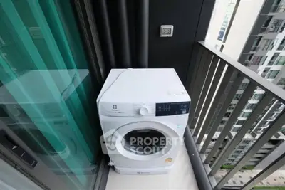 Compact balcony with washing machine in modern high-rise apartment.