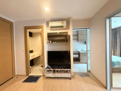 Modern apartment interior with wooden flooring, TV unit, and air conditioning, showcasing a cozy and functional living space.