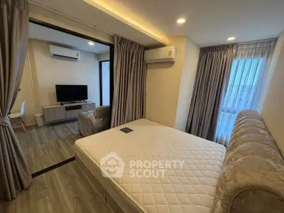 Modern bedroom with stylish decor and natural light, featuring a cozy bed and sleek furniture.