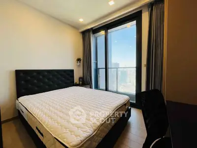 Modern bedroom with large window and city view, featuring a stylish bed and elegant decor.