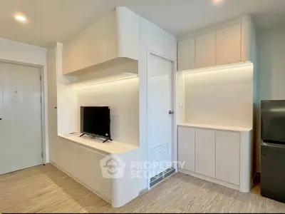 Modern minimalist living room with sleek cabinetry and mounted TV