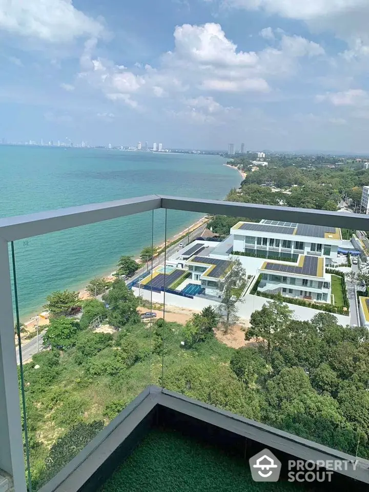 Stunning ocean view from high-rise balcony overlooking coastline and modern architecture.