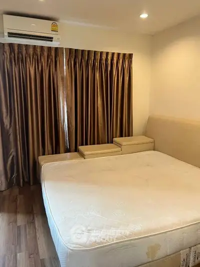 Cozy bedroom with elegant curtains and air conditioning, perfect for relaxation.