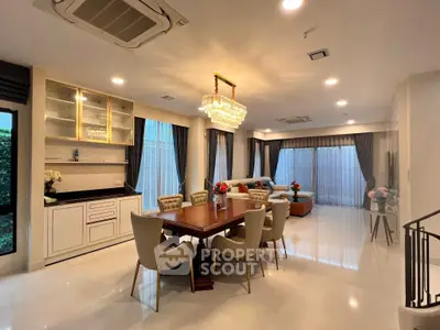 Luxurious open-plan living and dining area with elegant chandelier and modern furnishings.