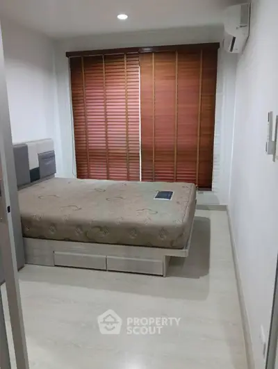 Modern bedroom with wooden blinds and air conditioning in a cozy apartment.