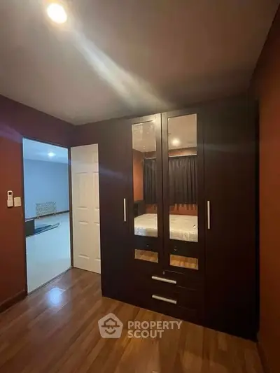 Spacious bedroom with elegant wooden wardrobe and cozy lighting