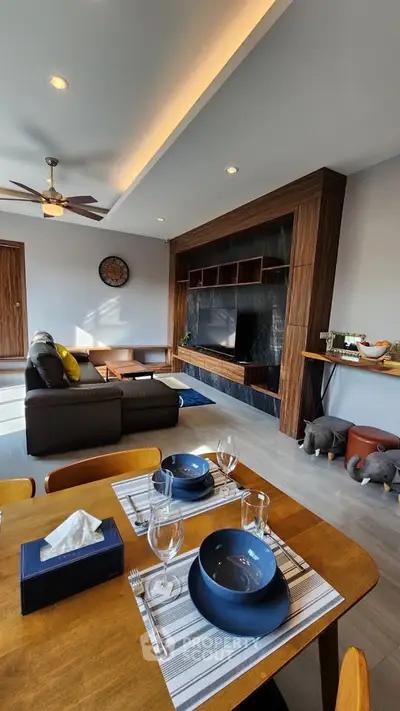 Modern living room with stylish decor and dining area, featuring elegant furniture and ambient lighting.