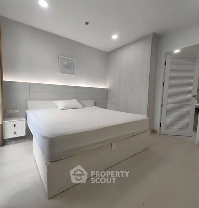 Modern minimalist bedroom with sleek design and ample storage space.