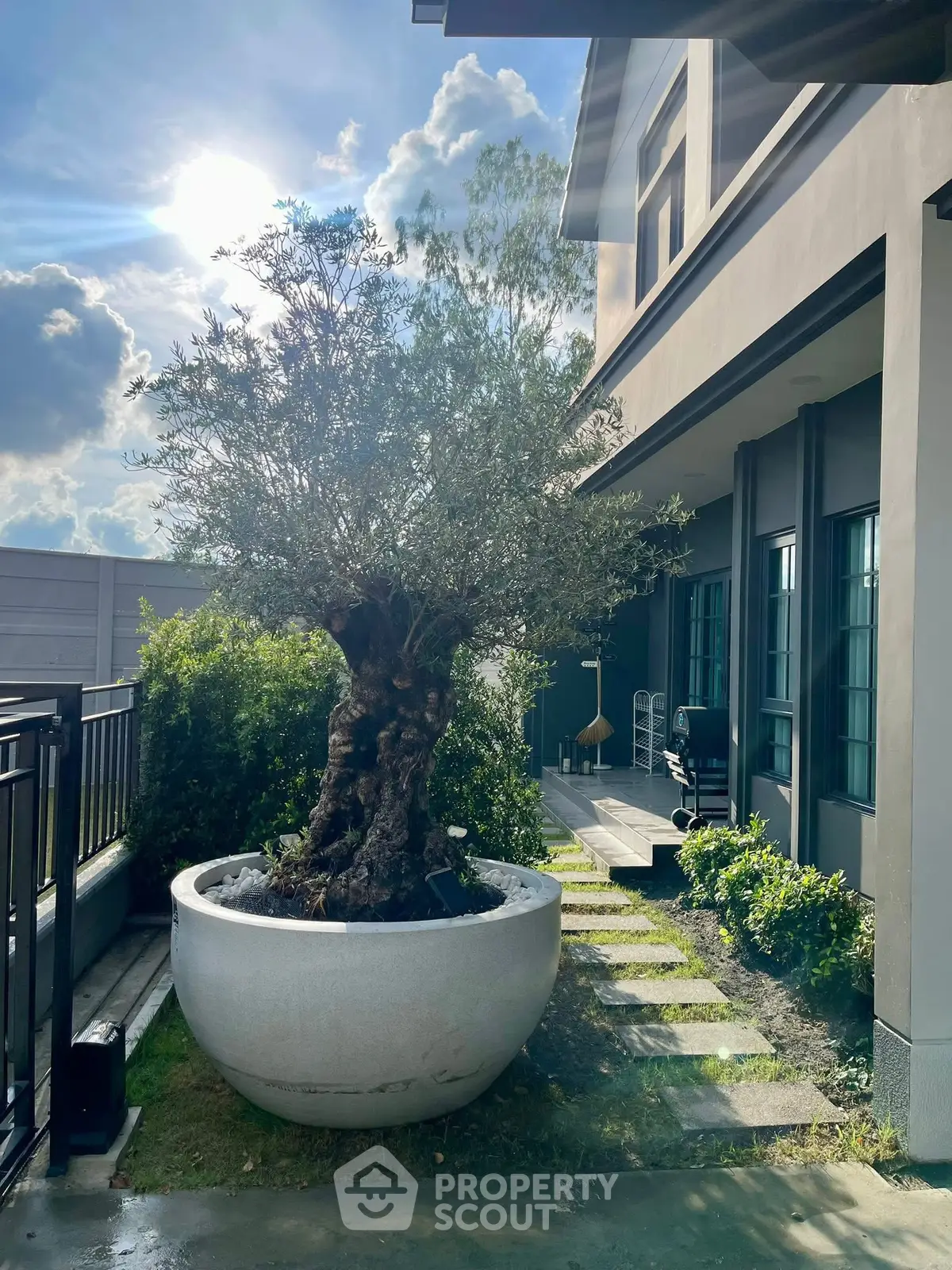 Charming exterior with lush garden and modern architecture under a bright sky.