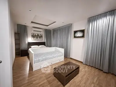 Spacious modern bedroom with elegant decor and wooden flooring