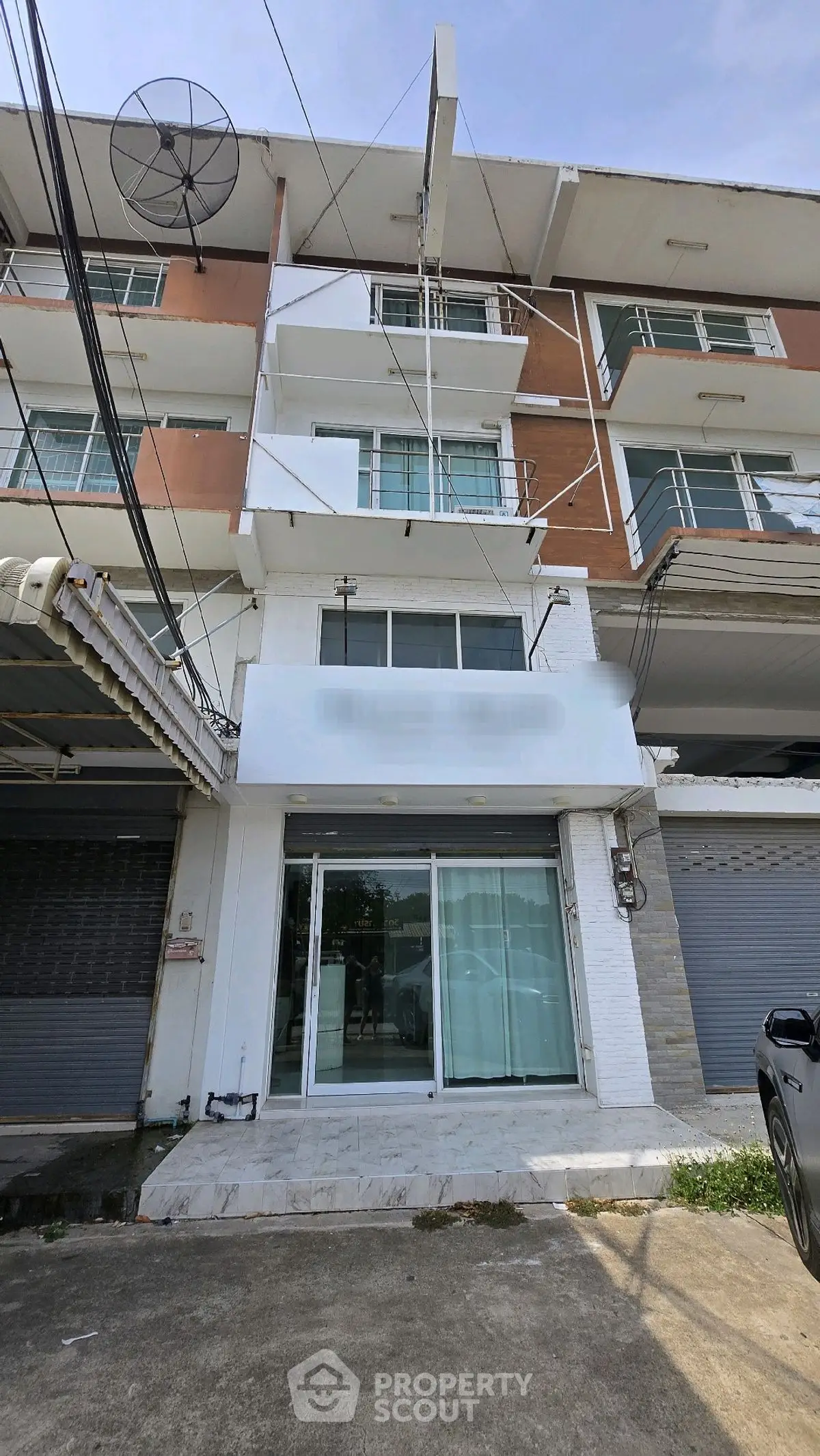 Modern multi-story building with large windows and balconies, ideal for urban living or business.