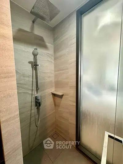 Modern bathroom shower with frosted glass window and sleek fixtures