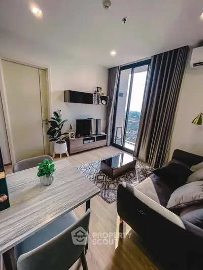 Modern living room with balcony view, stylish furniture, and elegant decor in a high-rise apartment.