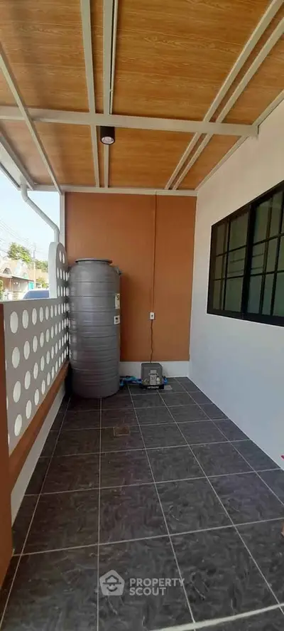 Spacious balcony with modern design and water tank, perfect for outdoor relaxation.