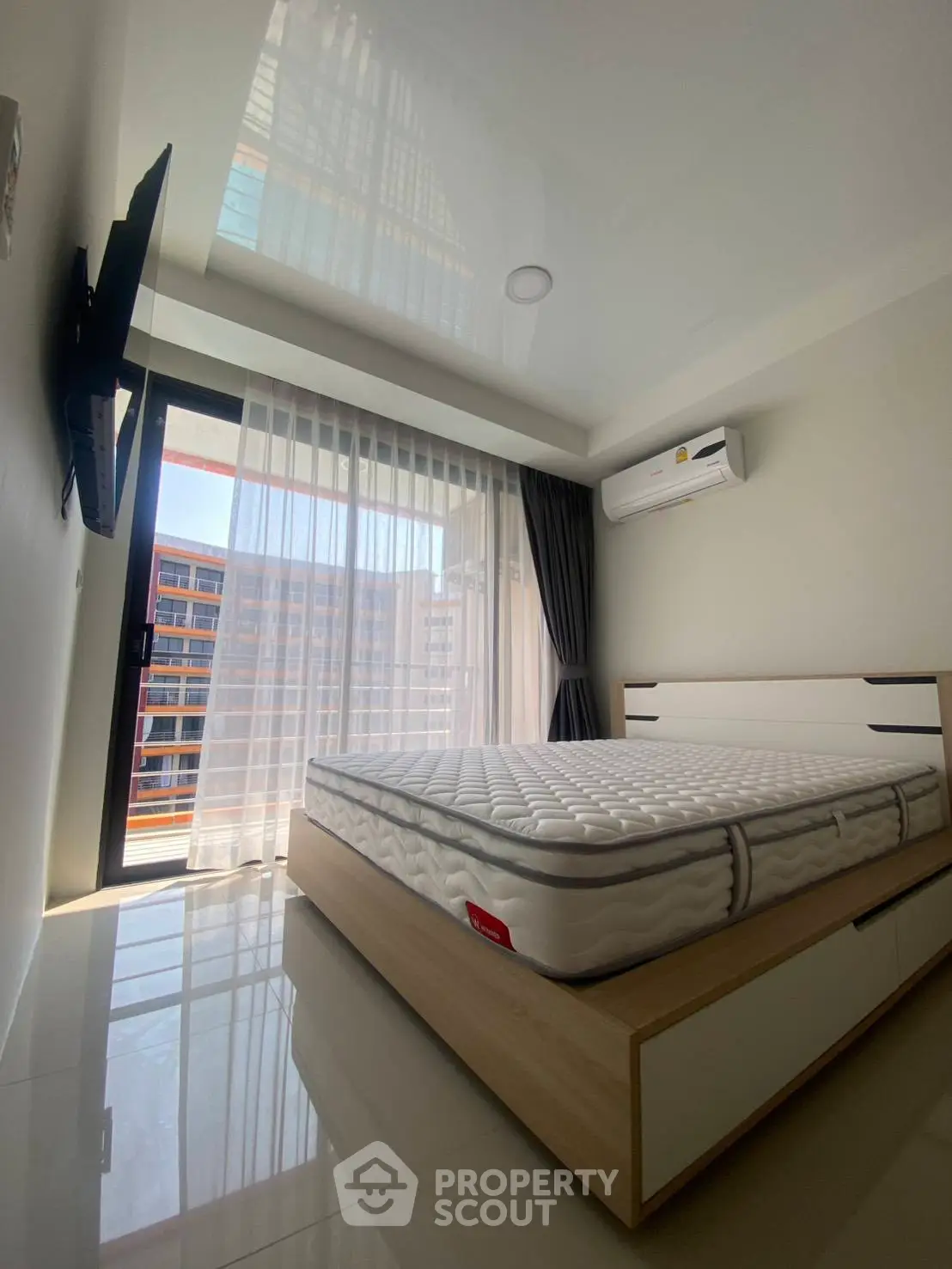 Modern bedroom with sleek design, large window, and air conditioning in a contemporary apartment.