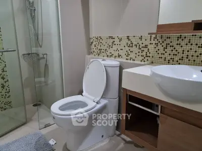 Modern bathroom with stylish mosaic tiles and glass shower enclosure