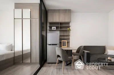 Modern studio apartment with sleek design, featuring a cozy living area and compact kitchen.