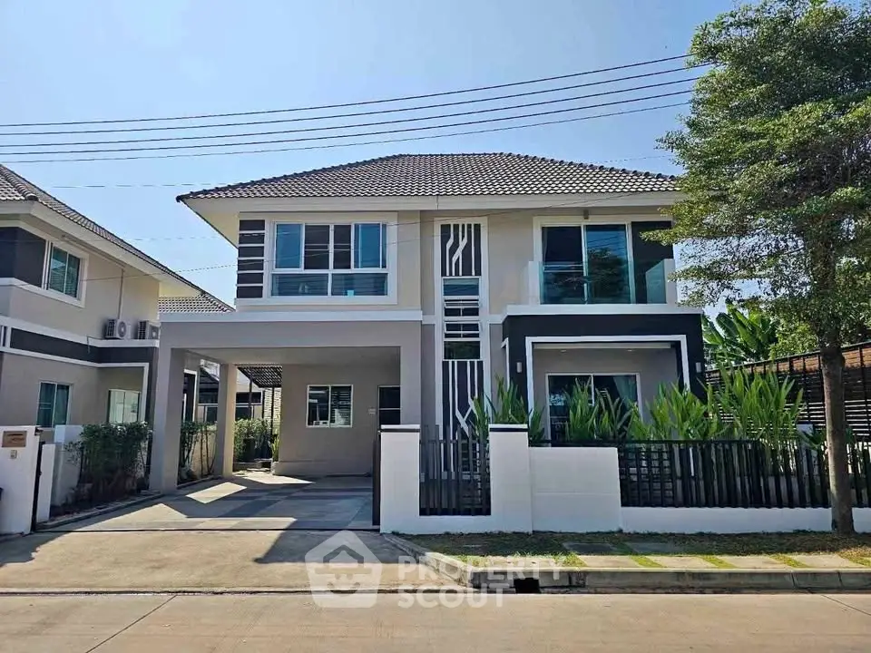 Modern two-story house with sleek design and spacious driveway in a serene neighborhood.