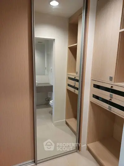 Modern bathroom with sleek wooden cabinetry and large mirror