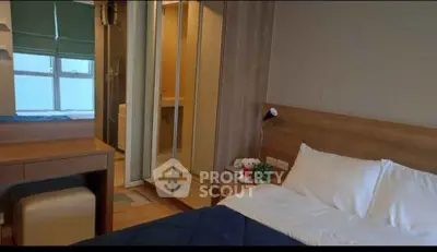 Cozy bedroom with mirrored closet and ensuite bathroom in modern apartment.