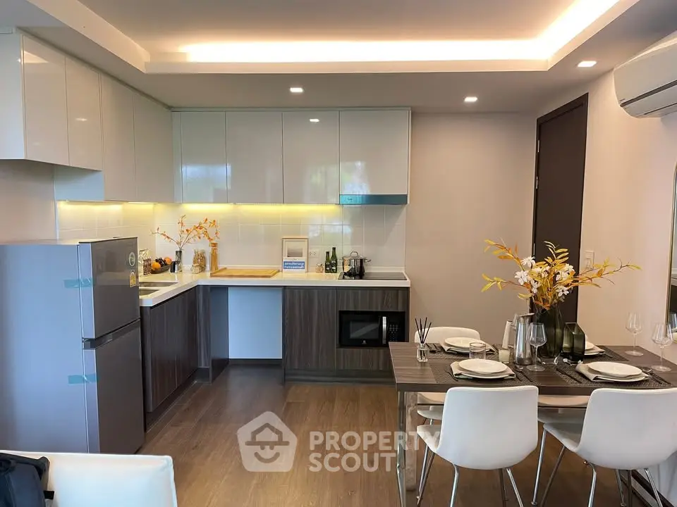 Modern kitchen with dining area, sleek cabinetry, and elegant lighting