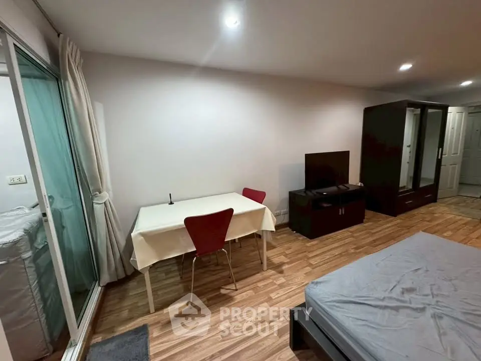 Modern studio apartment with wooden flooring and minimalist furniture