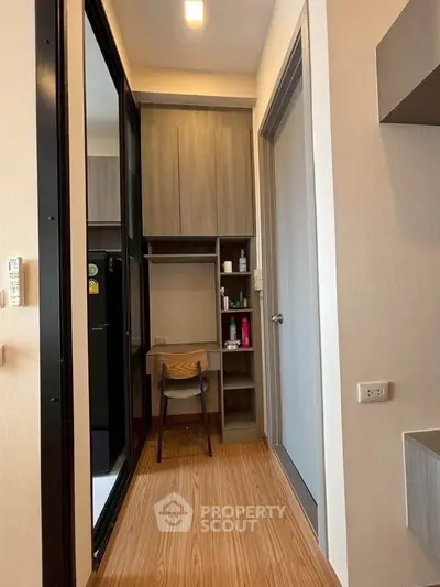 Compact study nook with wooden flooring and built-in shelves in modern apartment.