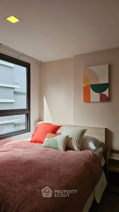 Cozy bedroom with modern decor and large window for natural light