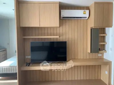 Modern bedroom with built-in wooden TV unit and air conditioning