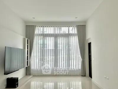 Spacious modern living room with large windows and sleek TV setup