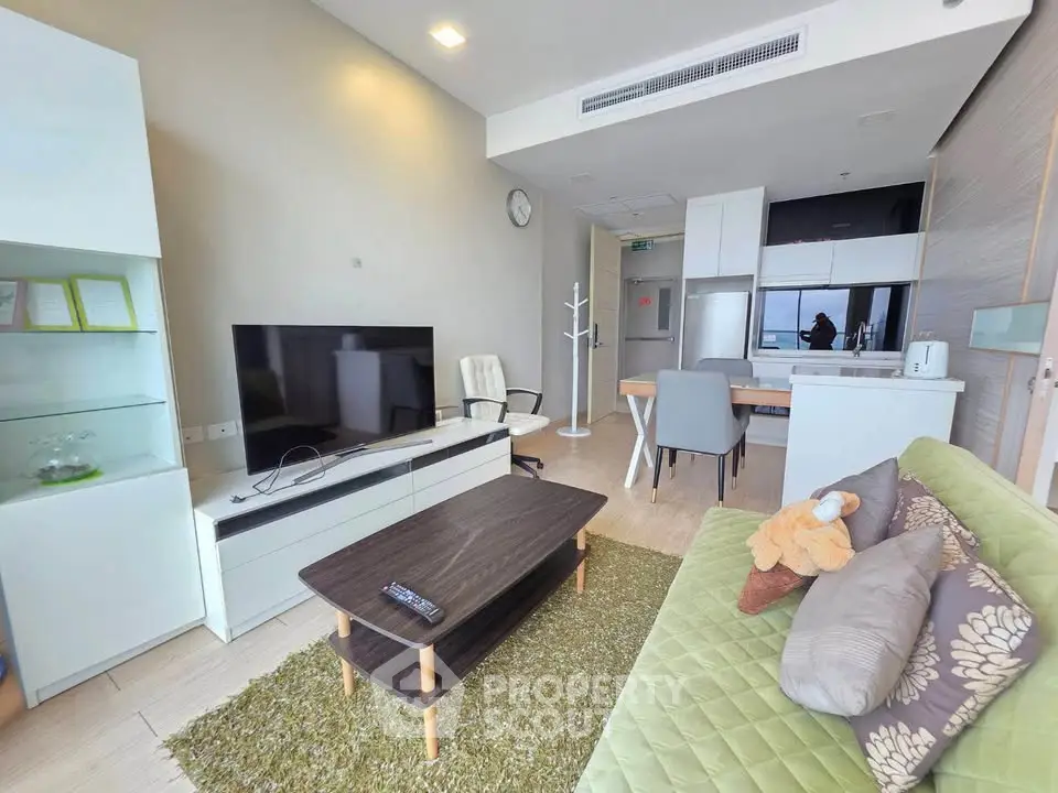 Modern living room with stylish furniture and open kitchen layout in a cozy apartment.