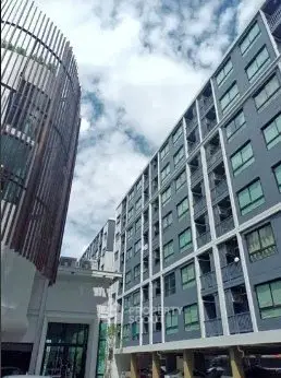 Modern urban apartment buildings with unique architectural design under a cloudy sky.