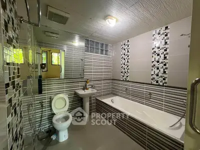 Modern bathroom with stylish tile design and bathtub in a contemporary home.