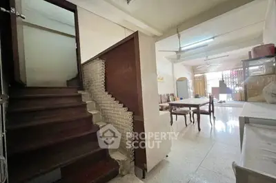 Spacious living area with wooden staircase and dining table, ideal for family gatherings.