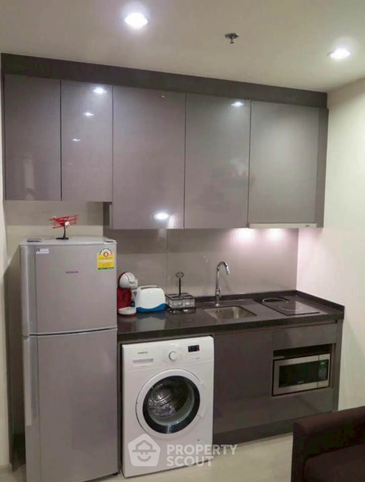Modern compact kitchen with appliances including washing machine and fridge