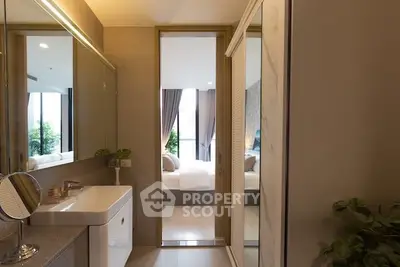 Modern bathroom with sleek design leading to a cozy bedroom with natural light.