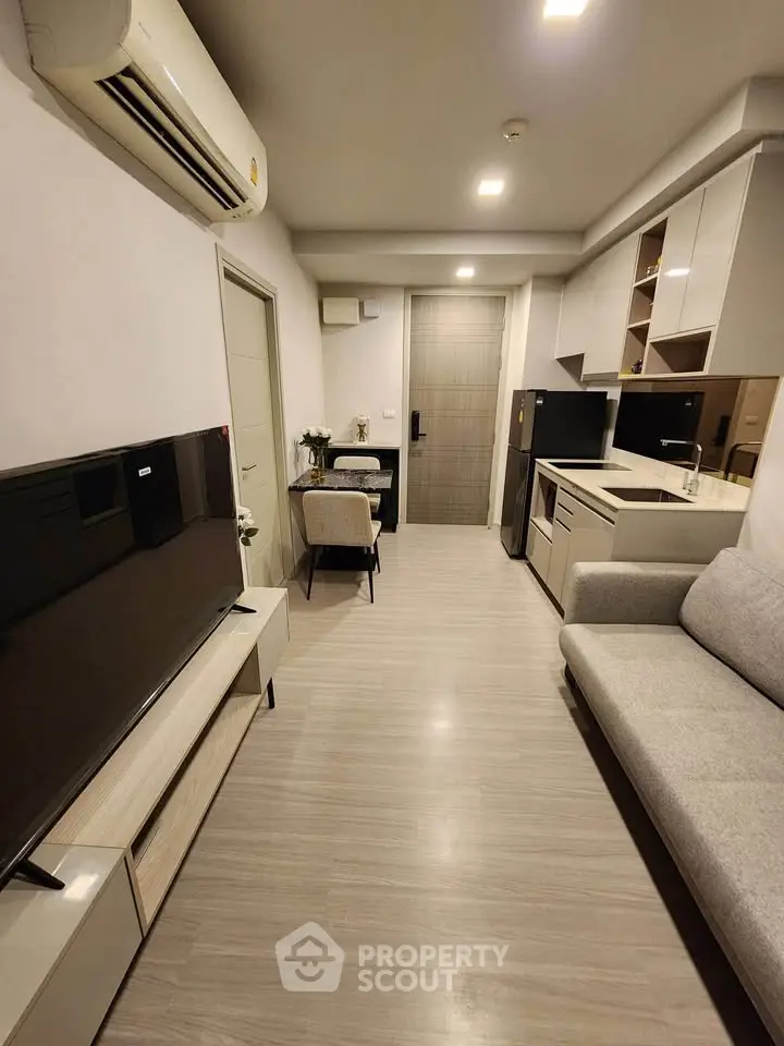 Modern living room with sleek furniture and open kitchen layout in a stylish apartment.