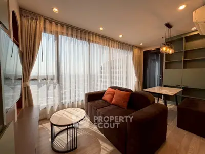 Modern living room with large windows and stylish furniture in a high-rise apartment.