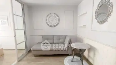 Elegant living room with modern decor and stylish furniture, featuring a comfortable sofa and decorative wall mirror.