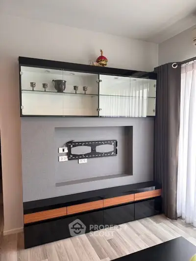 Modern living room with sleek black entertainment unit and glass cabinets