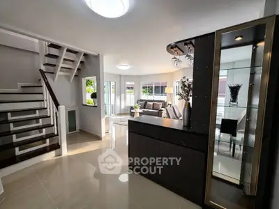 Modern open-plan living room with elegant staircase and stylish decor