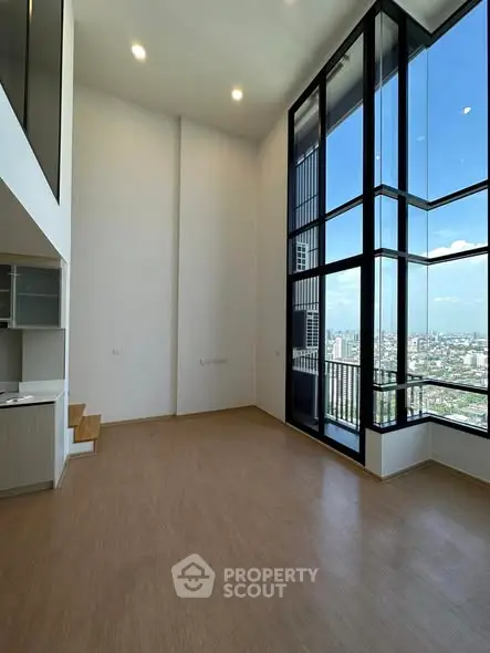 Stunning high-ceiling living room with floor-to-ceiling windows and city view.