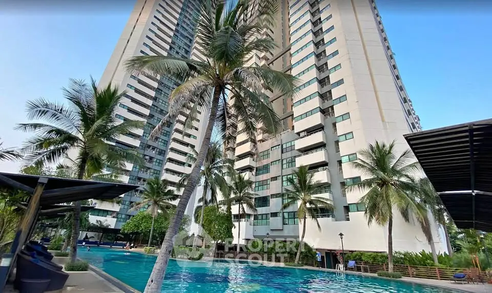 Luxurious high-rise building with stunning pool and lush palm trees, perfect for modern urban living.
