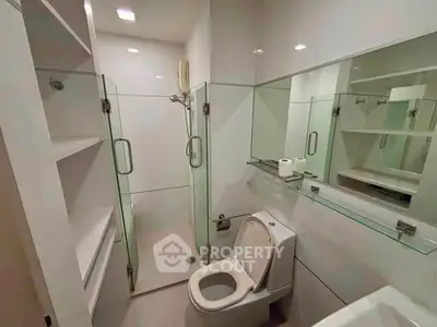 Modern bathroom with glass shower enclosure and sleek fixtures