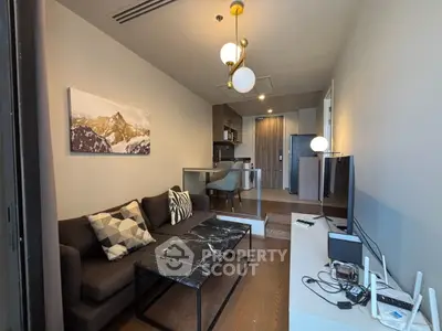 Modern living room with stylish decor and open layout, featuring a cozy sofa and elegant lighting.